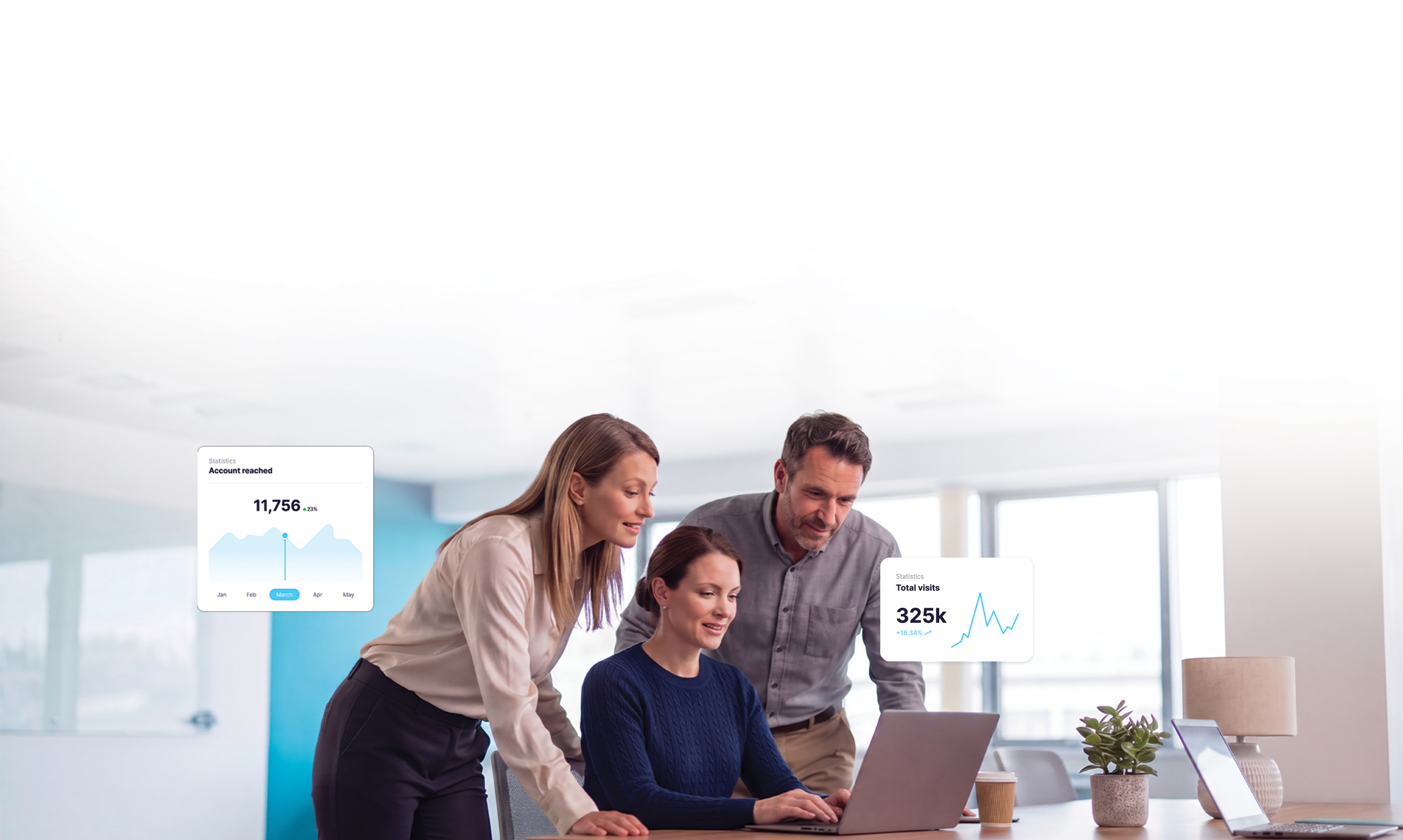 A team collaborating around a laptop in a bright office